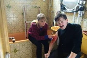 Angelika Flierl (Bernadette Heerwagen) leistet bei ihrem verletzten Entführer (Franz Dinda) erste Hilfe und näht eine Wunde.
