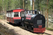 Eine als Dampflok verkleidete Diesellok fährt auf den Gleisen einer ehemaligen Grubenbahn durch den Märchenwald von Finnlands kleinstem Nationalpark Rokua.
