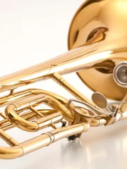 Old and used trombone on white background.