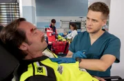 Nach einem Autounfall wird Hardy Wöhrl (Sven Gerhardt, l.) mit Verdacht auf ein Schädel-Hirn Trauma in der Notaufnahme eingeliefert. Mikko Rantala (Luan Gummich, r.) kümmert sich um den Patienten, während Annika Rösler (Paula Schramm, 2.v.r. mit Komparsin, 2.v.l.) Lioba Saetz (Lara Heller, liegend) untersucht.