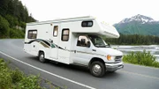 USA, Alaska, recreational vehicle driving on road, side view