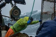 Deckhands on the Brenna A struggle to get a pot on board before a rogue wave hits the deck.
