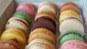A gift box of colorful French macarons in assorted flavors.