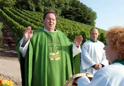 Pfarrer Braun (Ottfried Fischer) segnet zusammen mit Messdiener Armin (Antonio Wannek, re.) und der Roßhauptnerin (Hansi Jochmann) einen Weinberg. Pfarrer Braun (Ottfried Fischer) segnet zusammen mit Messdiener Armin (Antonio Wannek, re.) und der Roßhauptnerin (Hansi Jochmann) einen Weinberg.