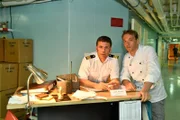 Im Bild: Chief Purser Holger (Daniel Wiemer, l.) und sein Freund Sous-Chef Thomas (Max Woelky, r.) machen sich Sorgen, dass Ihre „Leihgabe“ aus der Schiffskasse durch die neue Kollegin aufgedeckt wird.