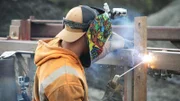 Ein Mann schweißt Metall mit einer speziellen Ausrüstung.