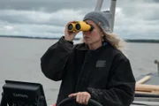 Elaine Adkison driving the Gold Ship with binoculars.
