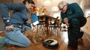 Irish Terrier Welpe Cuinn begegnet zum ersten Mal einem Staubsauger-Roboter.