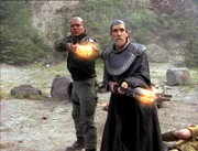 Teal'c (Christopher Judge, l.) und Bra'tac (Tony Amendola) eröffnen Feuer, jedoch ihre Waffen scheinen dem Gegner kein Leid zuzufügen.