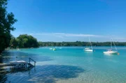 Boote liegen bei Sonnenschein und blauem Himmel auf dem Pilsensee.