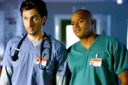 "Scrubs - Die Anfänger", "Mein Polizeistaat." Die neue Chefärztin Dr. Maddox behindert durch ihre rigorosen Kontrollmaßnahmen ein vernünftiges Arbeiten in der Klinik. Als J.D. und Elliot einer jungen Frau helfen wollen, die an Multipler Sklerose erkrankt ist, sich die teuren Medikamente aber nicht leisten kann, macht Maddox den beiden einen Strich durch die Rechnung. Ihre herzlose Art verärgert auch Cox. Frustriert schließt er sich mit dem Hausmeister zusammen, um Belastendes gegen Maddox zu finden, damit sie gefeuert wird.Im Bild (v.li.): Zach Braff (John 'J.D.' Dorian), Donald Faison (Chris Turk).