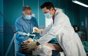 Stefan Brückner (René Steinke, liegend) wird nach einem schweren Verkehrsunfall in die Sachsenklinik eingeliefert. Gemeinsam mit Dr. Philipp Brentano (Thomas Koch, rechts) übernimmt Dr. Roland Heilmann (Thomas Rühmann, links) den Patienten.