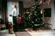 Tommy (Pär Sundberg, l.), Annika (Maria Persson, 2.v.r.) und ihre Eltern beim fröhlichen Tanz um den Weihnachtsbaum.