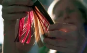 Besonders knifflig ist der Scheitel. Damit er natürlich fällt, hat Beate Dreher einen Knotentrick. Sie knüpft über Kreuz.; Die Haarfarben für die Perücke sucht Beate Dreher mit der Kundin immer gemeinsam aus.