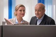 Bankangestellte Sigrun Moorkamp (Anna König) und Georg Wilsberg (Leonard Lansink) beobachten Jette Retzlaff und Uli Pape dabei, wie sie vor der Bank neue Kunden werben.