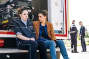 Kommissarin Amira Mahdi (Aylin Ravanyar, l.) steht unter Schock, nachdem sie während eines Einsatzes Zeugin eines grausamen Mordes wurde. Bei ihr sitzt Lilly Funke (Tatjana Kästel). (Komparsen im Bild)