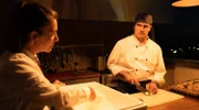 Die neue Chefin Sobral (Lúcia Moniz, li.) ermittelt undercover und hat ein wachsames Auge auf den Koch Pedro Lino (Lourenço Henriques, re.).