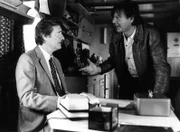 Josef Haslbeck (Helmut Fischer, links) hat einen Job beim Gebrauchtwagenhändler Schorschi Gruber (Hans Brenner), den er im Krankenhaus kennenglernt hat, angenommen. Dieser ist mit ihm aber gar nicht zufrieden.