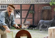 Der Bauer (Florian Martens) beim Schleifen des Schlachtermessers.