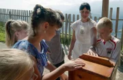 Luzia Kupplewieser lehrt die Kinder bei der Verarbeitung von Butter.