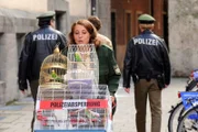 Thekla (Luise Kinseher bringt die Vögel weg, die die Nachbarn von Frau Bichler im Revier abgeliefert haben. Xaver (Andreas Giebel, im HG. l.) und Felix (Florian Karlheim, im HG. r.) bringen unterdessen Torsten Aumüller aufs Revier.