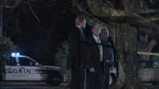 Three cops are in the shadows.