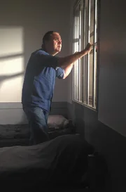 Man looking out window.