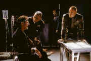 Dr. Franklin (Richard Biggs, Mi.), Michael Garibaldi (Jerry Doyle, re.) und der Telepathin Lyta Alexander (Patricia Tallman) ist es gelungen, bis zu Captain Sheridan (Bruce Boxleitner, li.) vorzudringen, der seit einer Woche verhört wird und offenbar unter Drogen gesetzt wurde.