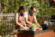 Ivana und Adnan bereiten lachend das Fladenbrot vor.