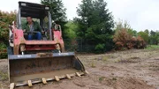 Brian is sitting in the tractor before dig begins driving unaware, as seen on DIY Pool Kings.