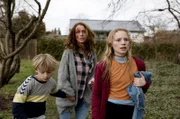 Dea (Christine Albeck Børge, Mi.) ergreift mit Theo (Noah Storm Otto, li.) und Holly (Flora Ofelia Hofmann Lindahl, re.) die Flucht.