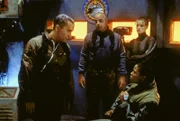 Dr. Franklin (Richard Biggs, li.), Michael Garibaldi (Jerry Doyle), Nummer 1 (Marjorie Monaghan, hinten) und eine Offizierin auf einem der Stützpunkte der Erdstreitkräfte auf dem Mars.