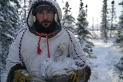 Hazen mit einem toten Schneehasen, der in einer Falle gefangen wurde.