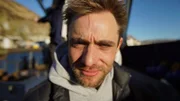 Jake Anderson present day looking into camera.