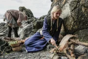 Reenactors Wikinger, kochen Fisch und reparieren ihre Fischernetze.