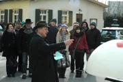 Bürgermeister Schattenhofer (Werner Rom) enthüllt das Kunstwerk, das künftig den Dorfplatz schmücken soll.