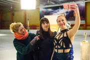 Während Steffi (Madeleine Krakor, l.) dafür sorgt, dass die Mädchen bei dem Shooting gut aussehen, haben Michelle (Franziska Benz, M.) und Marie (Cheyenne Pahde) auf dem Eis zusammen Spaß.