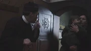 Der Priester ermahnt die Frau mit dem Kind, ruhig zu sein.