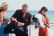 Alex (Mitzi Kapture, l.) musste aus der Show aussteigen. Dafür gibt es vom Moderator (Alex Trebek, r.) jede Menge Trostpreise.