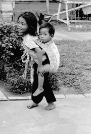 Dieses 8-jährige Mädchen, eine Bettlerin, trägt ihren „Bruder“, der nicht zu ihrer Familie gehört, sondern tageweise von seiner Mutter gemietet wird, am 12. Januar 1968 in Saigon. In Saigon, wo hochrangige amerikanische Offiziere lebten, fällt es ihnen schwer, ihr eine Münze zu geben, obwohl sie ihre Geschichte kennen.