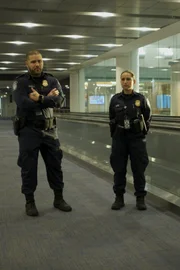 Miami, FL - Officers Adriel and Claudia Pupo stand guard as they await for passengers coming from departing flights.