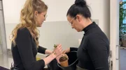 Floristin Viebi zeigt Lena, wie Blumen richtig gewässert werden.