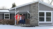 From left to right: Host David Bromstad, Brittany Godlewski, and Coty Nail pose for a picture outside of House 1, Gopher Hill, as seen on My Lottery Dream Home, Season 17.