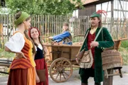 Rotkäppchen (Kathleen Frontzek) freut sich mit ihrer Mutter (Rebecca Immanuel) über deren Freundschaft zum Jäger (Frank Stieren). Konrad (Max von der Groeben) will mit Rotkäppchen auf seinem Wagen einen Ausflug machen.