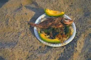 Auf Jamaika bereitet Sana am Strand Bratfisch zu.