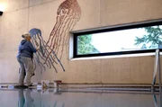 Auf der Wasseroberfläche gespiegelt ist das Quallenmosaik von Mosaizistin Tanja Lebski.