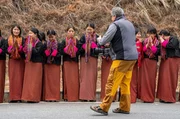 Schülerinnen warten auf eine buddhistische Segnung am Straßenrand in Phunaka (Bhutan)
