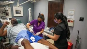 Dr. Lee works on removing lumps from Mike Asai’s legs.