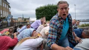 Panik bricht aus, als bei einer Großveranstaltung, die Dan (Peter Mygind) und sein Team überwachen, plötzlich ein Schuss fällt (Hintergrund: Komparsen).