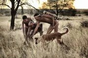 Eine französische Bulldogge bei einem Experiment mit einem Roboterhund.; Alonso und Jack, zwei von der Straße gerettete spanische Streuner.; San-Jäger mit ihrem Africanis-Hund in Namibia.